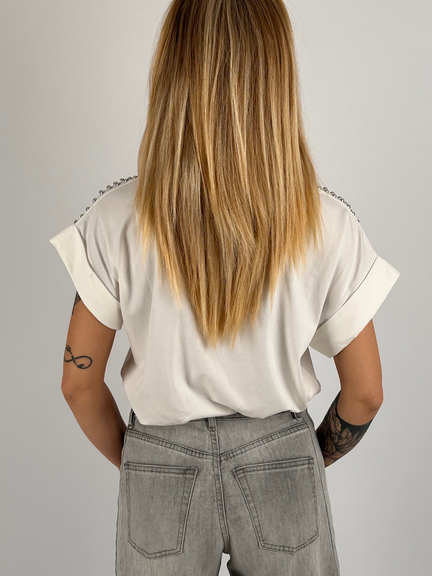 T-shirt donna bianco con micro borchie decorative sulle spalle e vestibilità morbida stile casual chic. vista retro