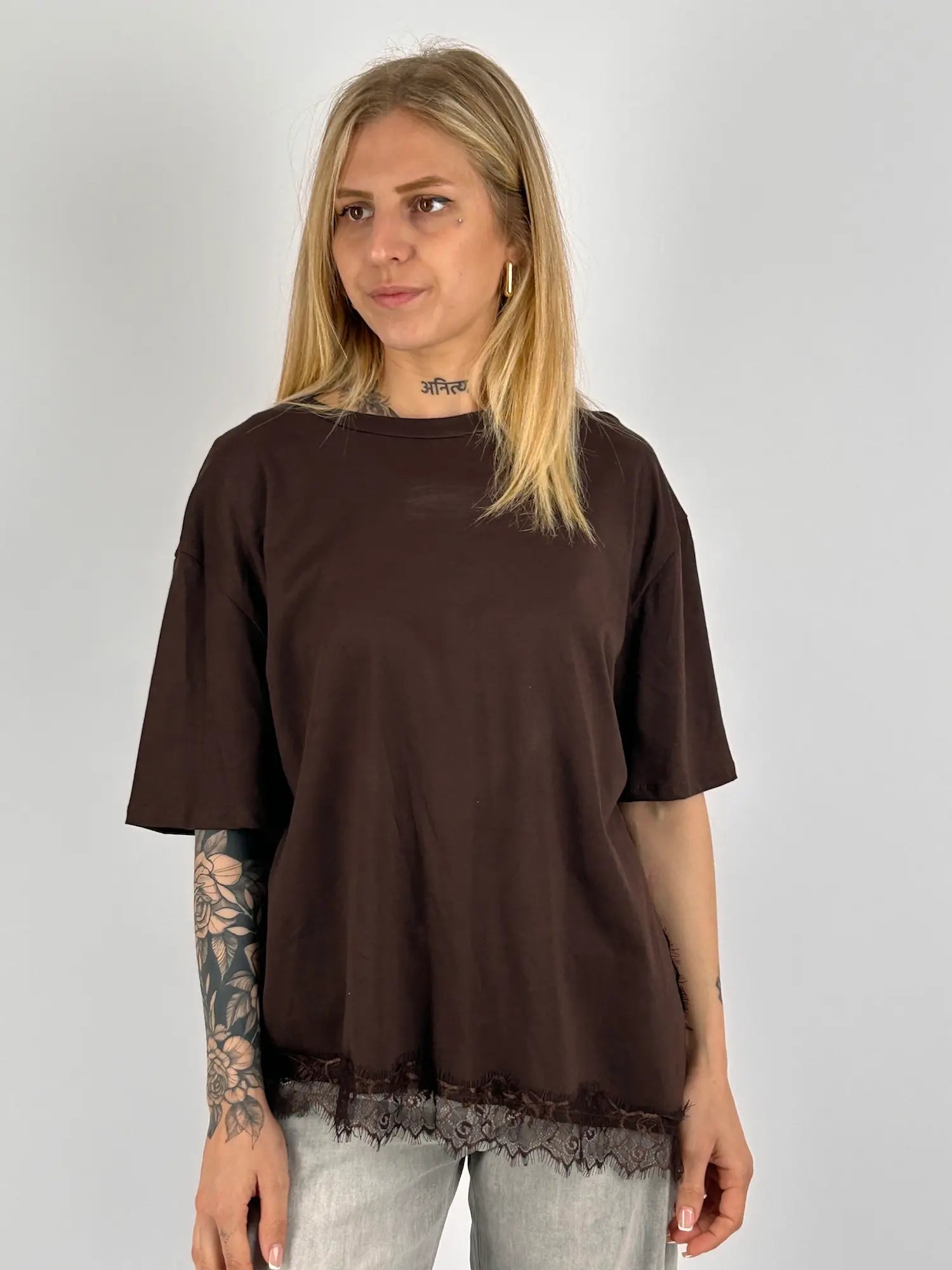 T-shirt donna marrone over con dettaglio in pizzo sul fondo indossata con jeans chiari.vista frontale
