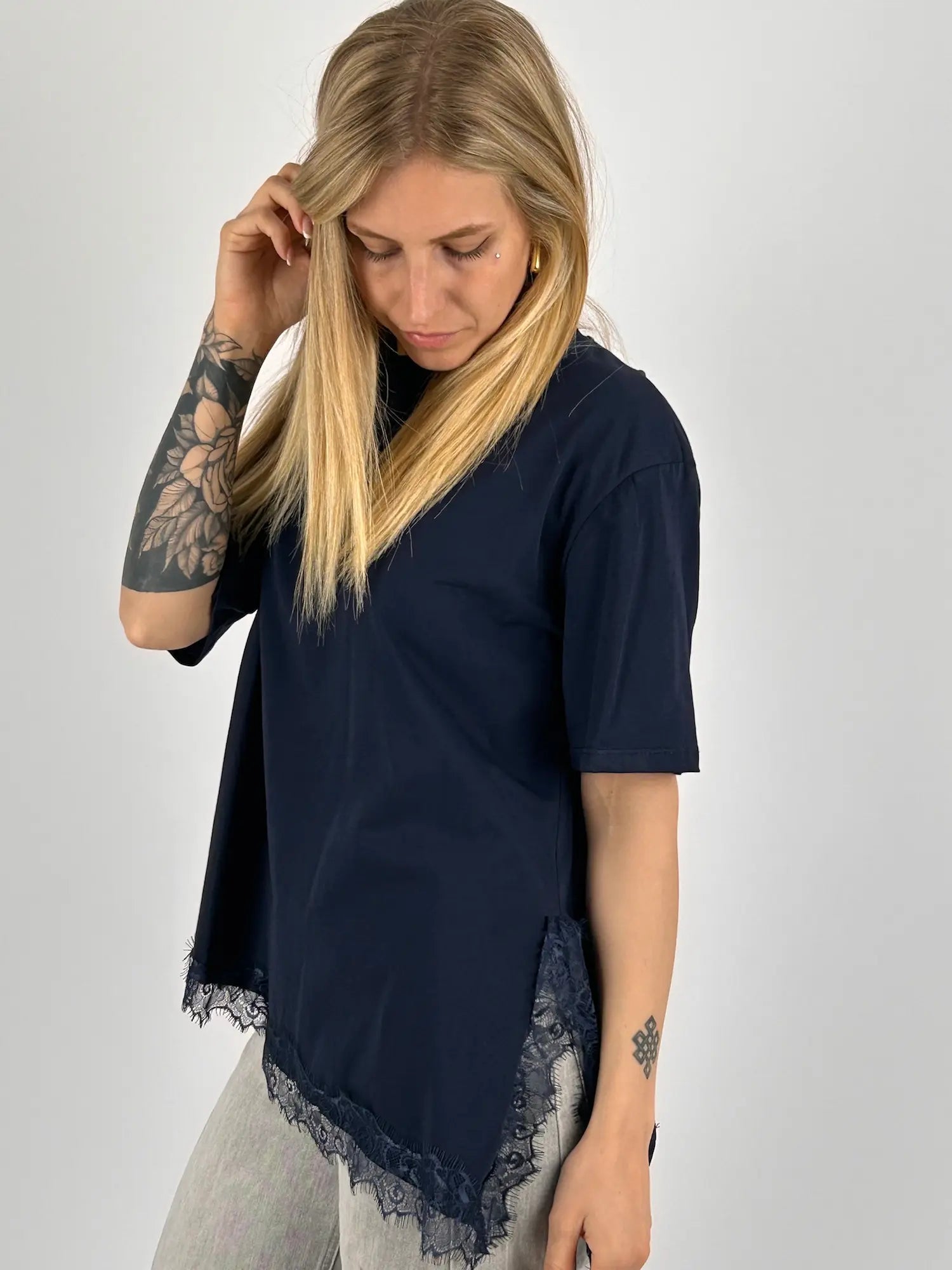 T-shirt donna blu over con dettaglio in pizzo sul fondo indossata con jeans. vista frontale 